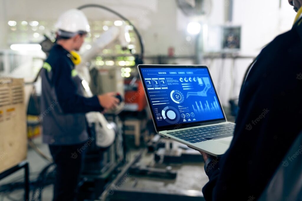 Factory workers working with adept robotic arm in a workshop